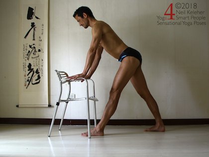 Pyramid standing hamdstring stretch with hands on chair. Neil Keleher. Sensational Yoga Poses.