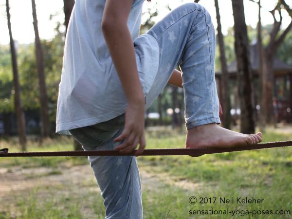 Getting ready to step on to a slack line.  Neil Keleher, Sensational Yoga Poses.